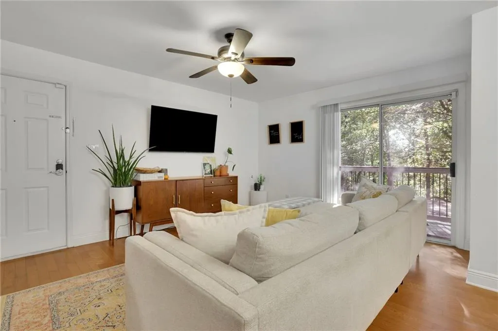 Living room with light hardwood / wood-style flooring and ceiling fan