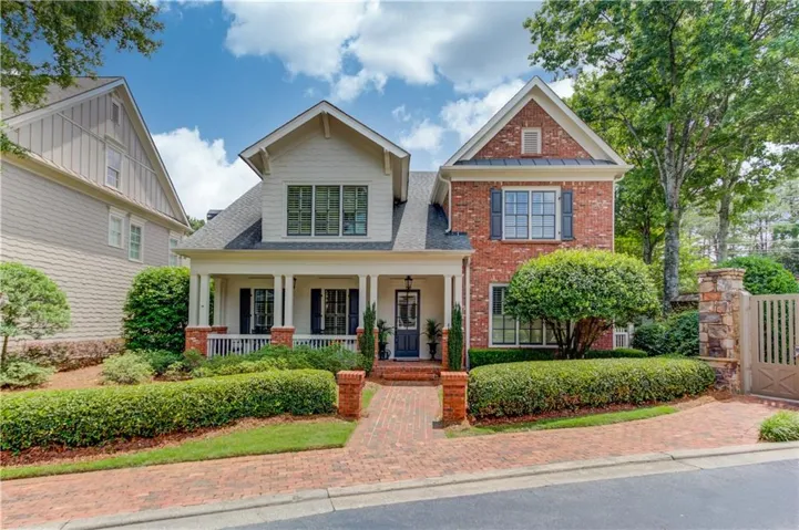 Traditional-style residence featuring a brick and siding facade with a covered front porch