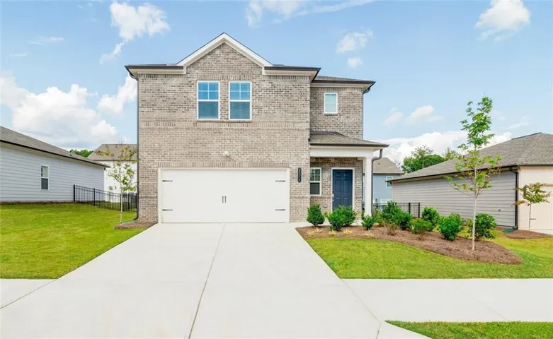 View of front of property featuring brick siding, an attached garage, and driveway