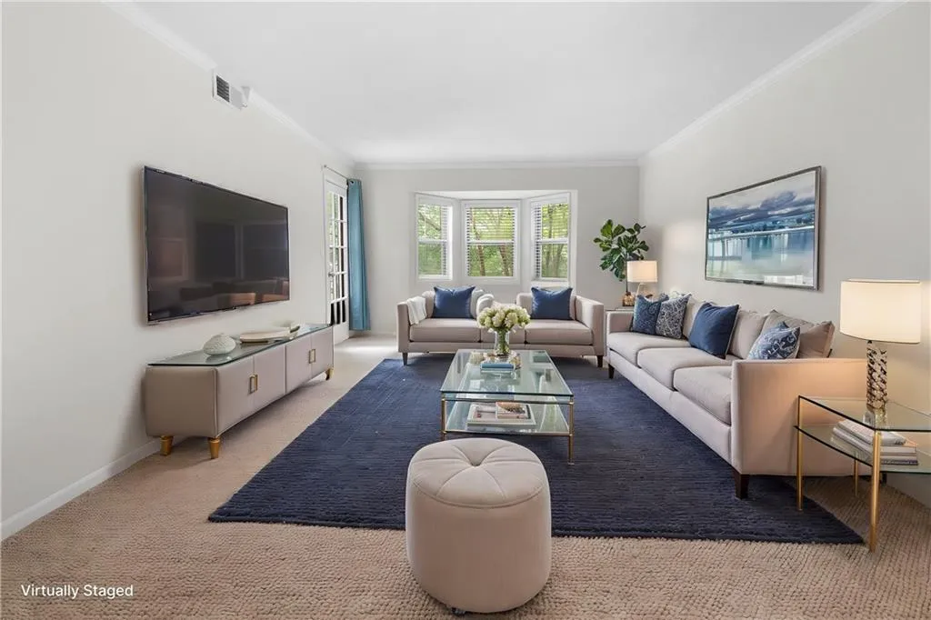 Living room featuring light carpet and ornamental molding