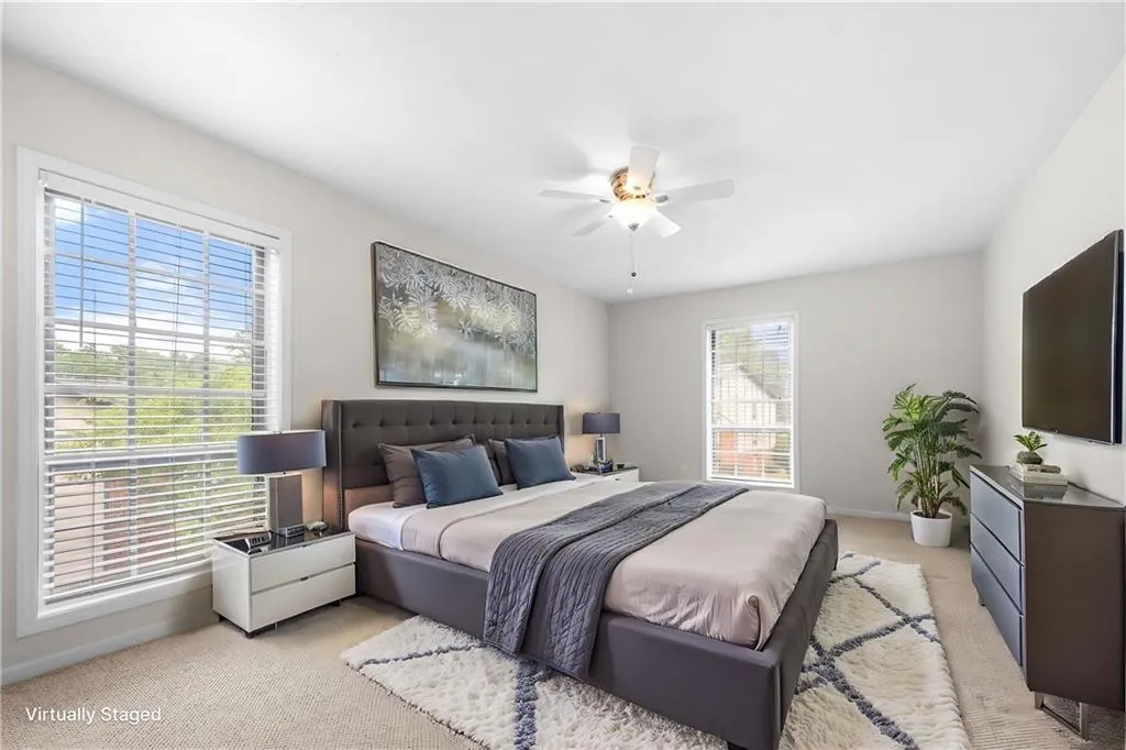 Bedroom with multiple windows, ceiling fan, and light carpet