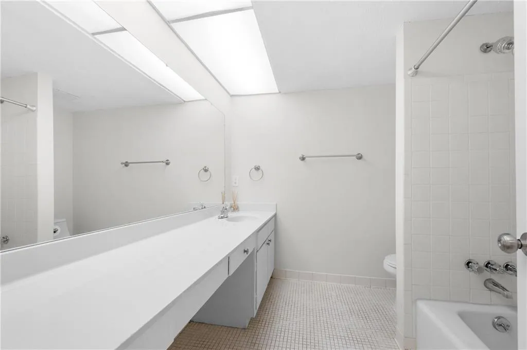 Full bathroom featuring tiled shower / bath, tile patterned flooring, vanity, and toilet