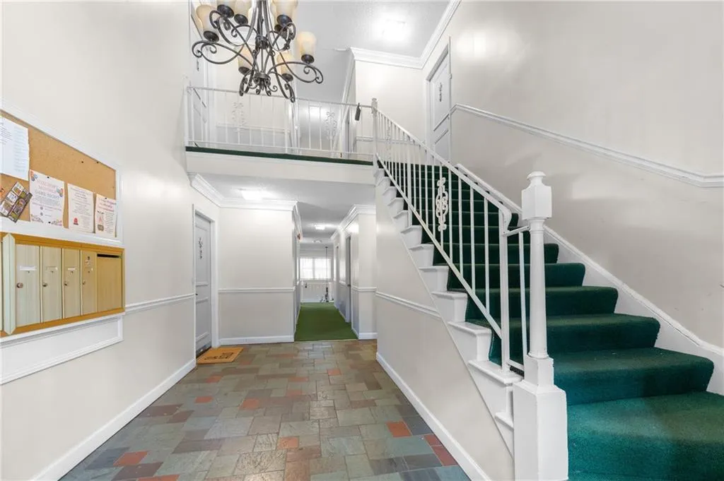 Staircase with a high ceiling, an inviting chandelier, and ornamental molding