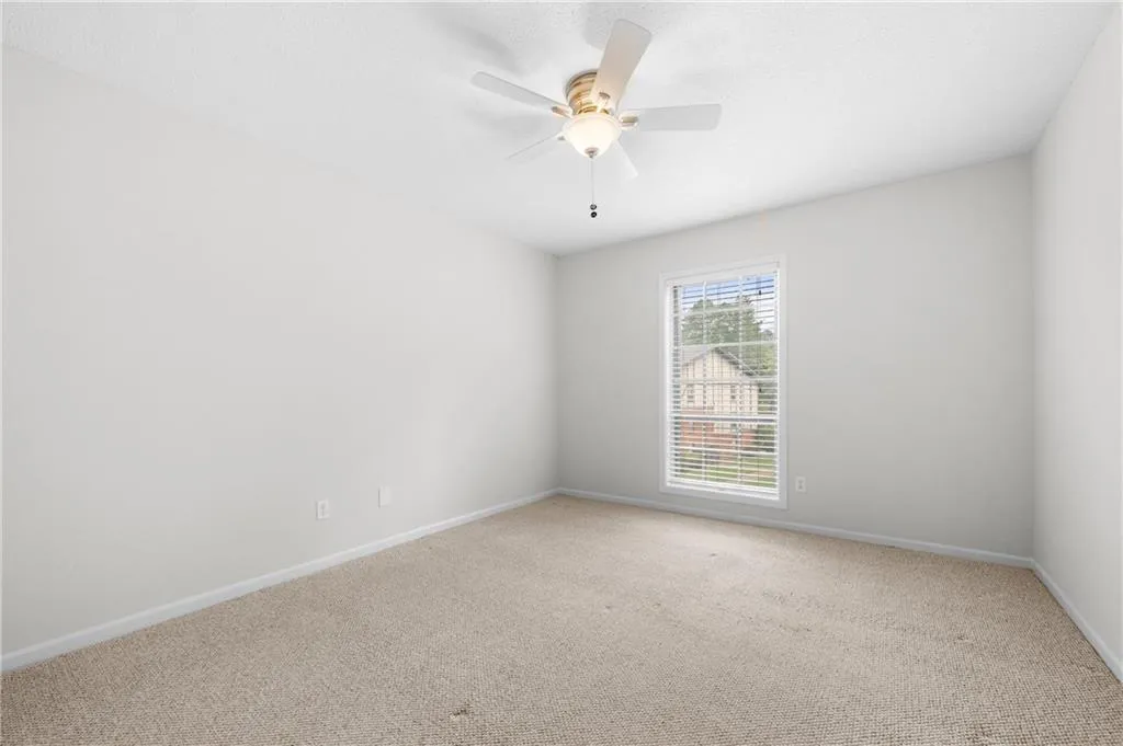 Carpeted empty room with ceiling fan