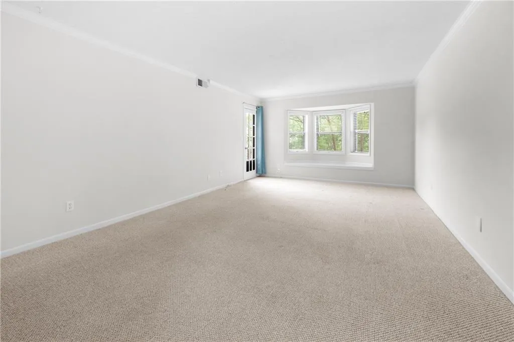Carpeted living room with ornamental molding