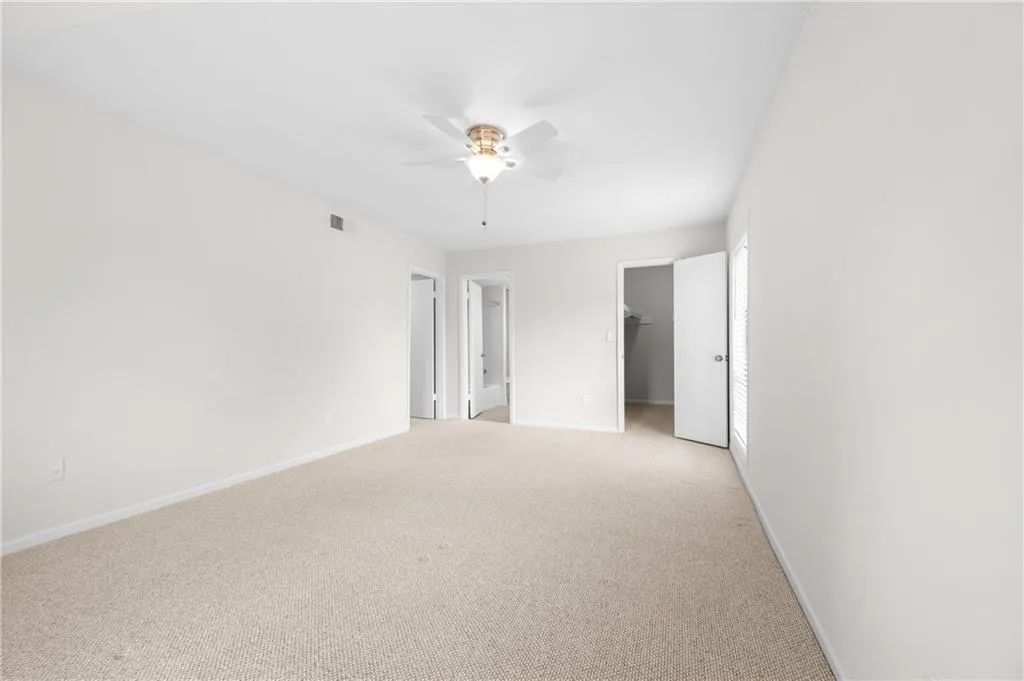 Carpeted spare room with ceiling fan
