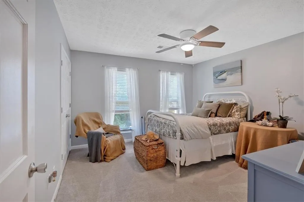 Additional Large Bedroom with ceiling fan, light colored carpet and large closet. Great room mate floor plan.
