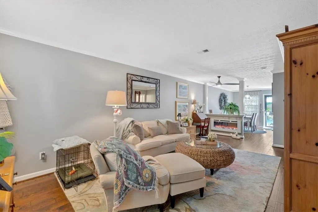 Living room featuring crown molding, ceiling fan, and light hardwood / wood-style flooring