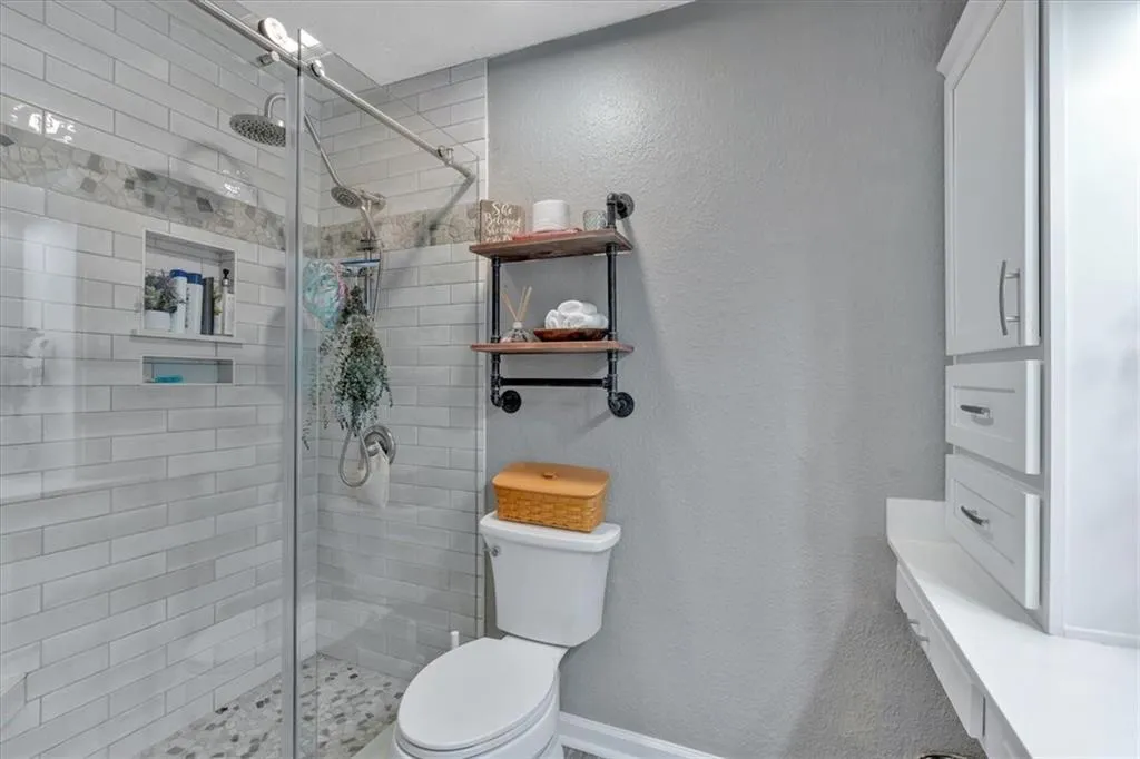 Bathroom featuring vanity, toilet, and a custom walk-in shower with glass  shower door