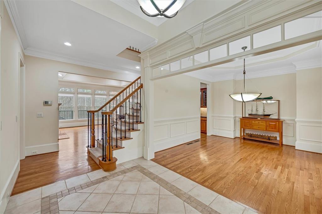 Tiled entryway featuring crown molding
