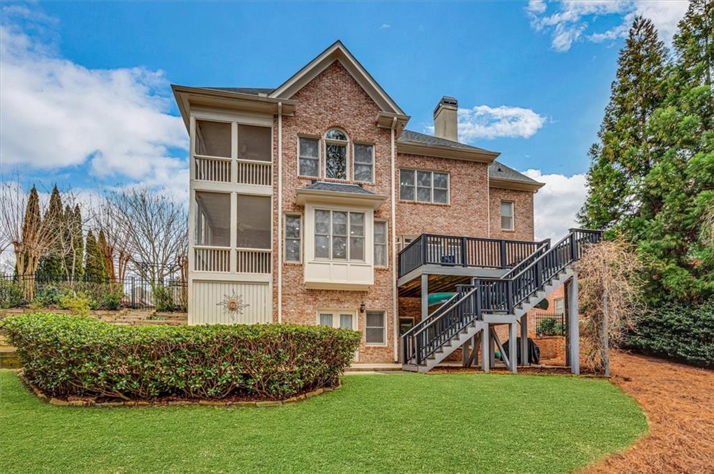 Back of property with a wooden deck and a lawn