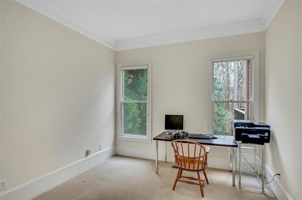 Home office featuring crown molding and light colored carpet