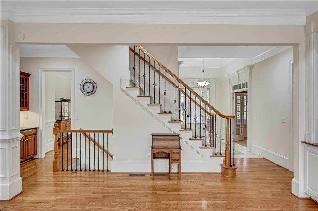 Stairway featuring french doors, crown molding, and light wood-type flooring