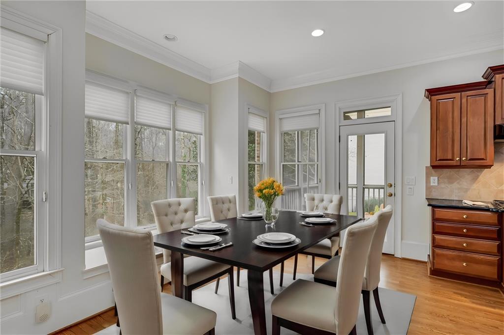 Dining room featuring light hardwood / wood-style flooring, crown molding, and plenty of natural light