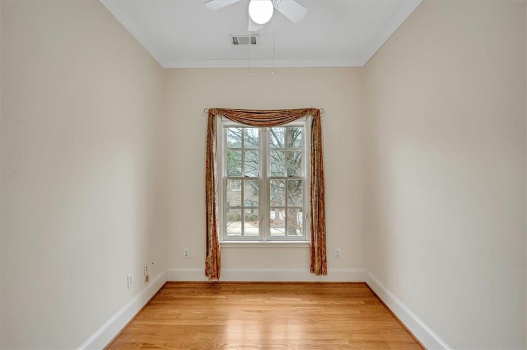 Spare room featuring light hardwood / wood-style flooring, ceiling fan, and ornamental molding