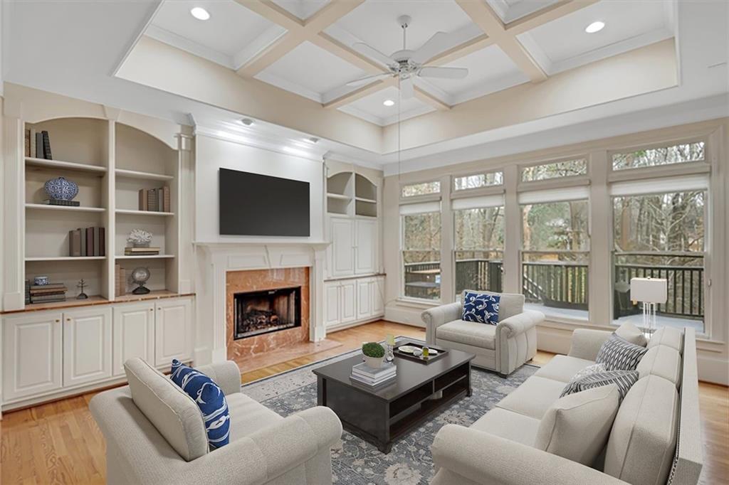 Living room featuring coffered ceiling, light hardwood / wood-style flooring, a high end fireplace, and ceiling fan