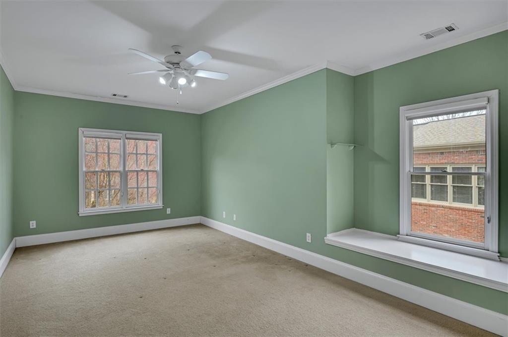 Spare room with crown molding, ceiling fan, and light carpet