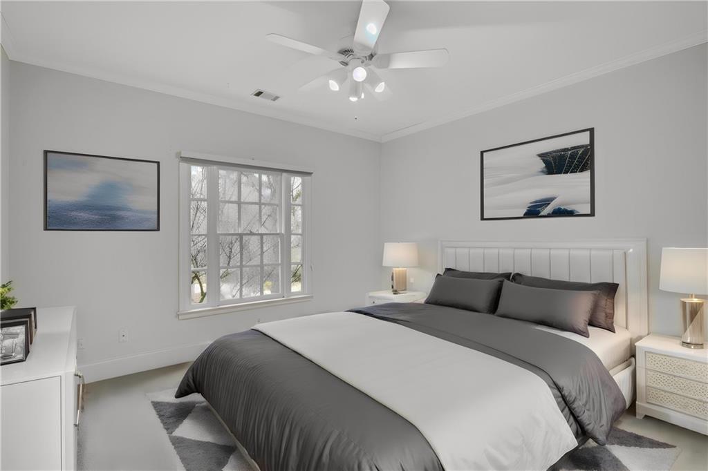 Carpeted bedroom featuring crown molding and ceiling fan