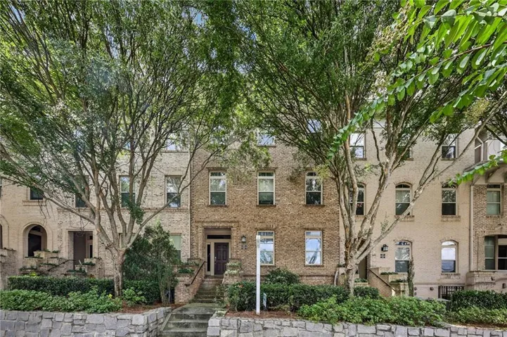 Brick exterior with stone accents, mature trees, multi-pane windows, and a multi-level entry
