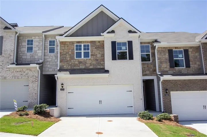 Stone and brick facade with vertical siding accents, dual-pane windows, decorative shutters, and an attached two-car garage