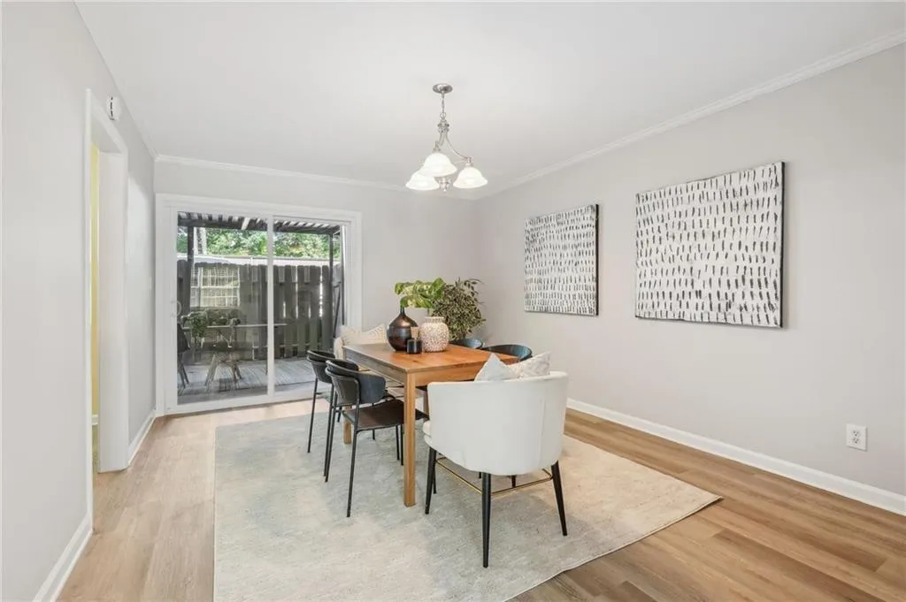 Dining area with a chandelier, ornamental molding, and light hardwood / wood-style flooring