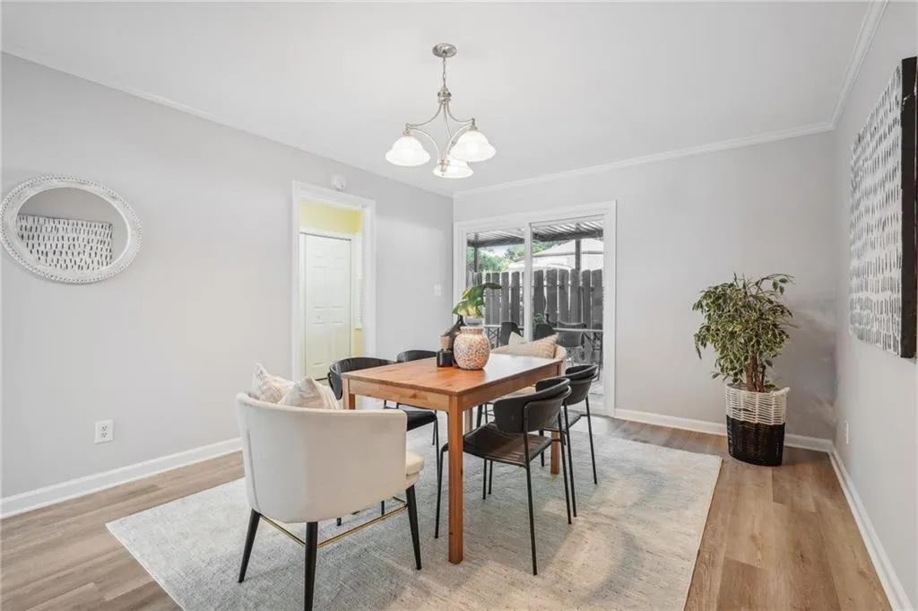 Dining space featuring an inviting chandelier, ornamental molding, and light wood-type flooring