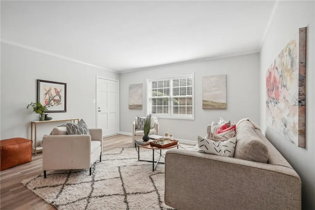 Living room featuring ornamental molding and hardwood / wood-style flooring