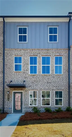 Contemporary townhome exterior featuring a gray brick facade and board and batten siding