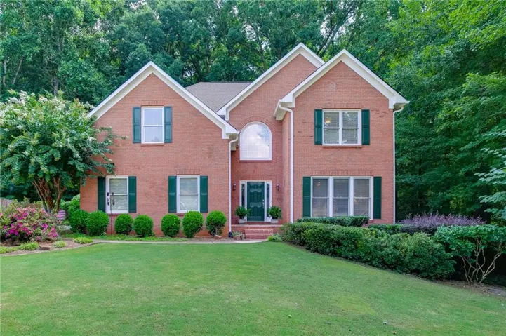 Brick exterior with white gables, arched transom window, and dark shutters