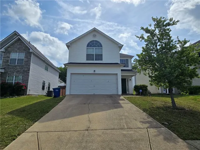 Two-story facade with white siding and an arched window accent