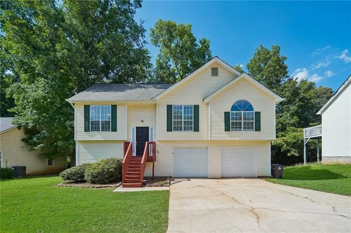 Two-story residence featuring light-colored siding, contrasting green shutters, and a dark entry door