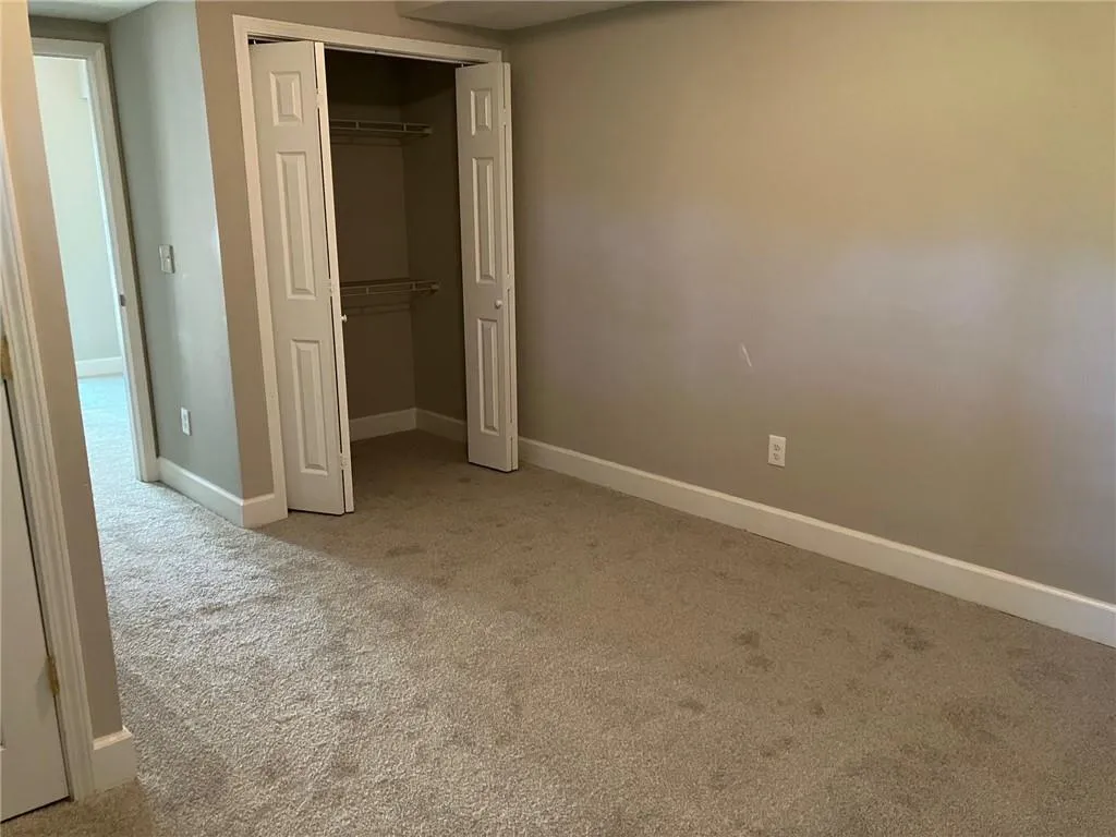 Unfurnished bedroom featuring light colored carpet and a closet