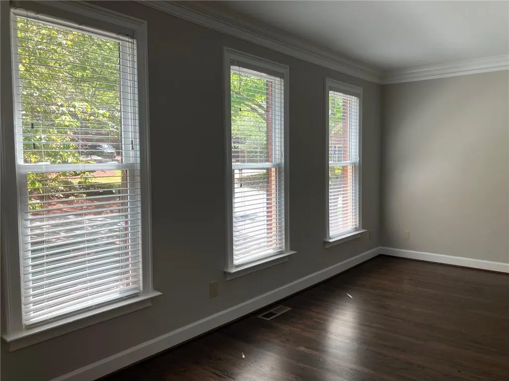 Unfurnished room featuring dark hardwood / wood-style floors and ornamental molding