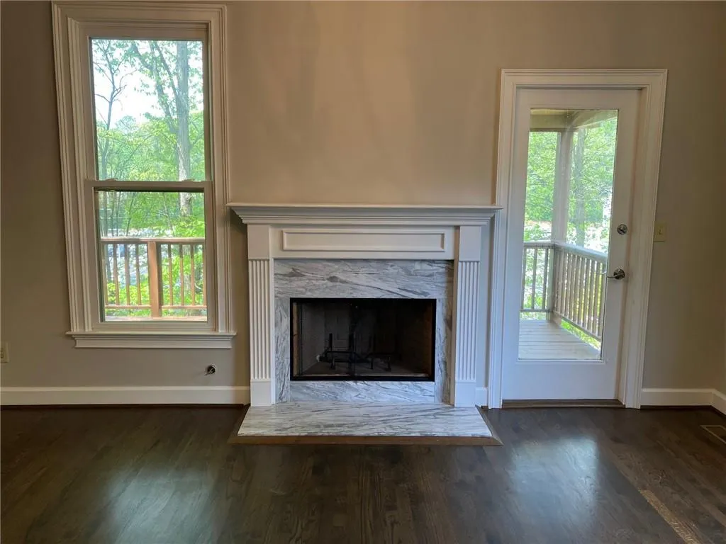 Unfurnished living room with a fireplace and dark wood-type flooring