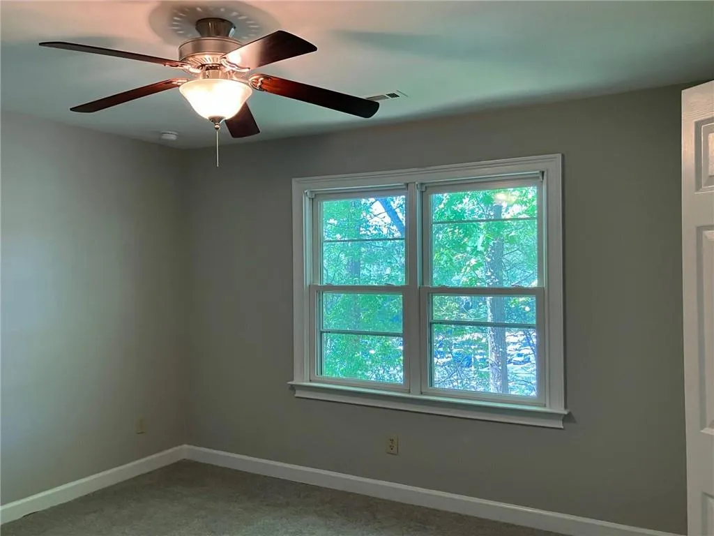 Spare room featuring ceiling fan and carpet flooring