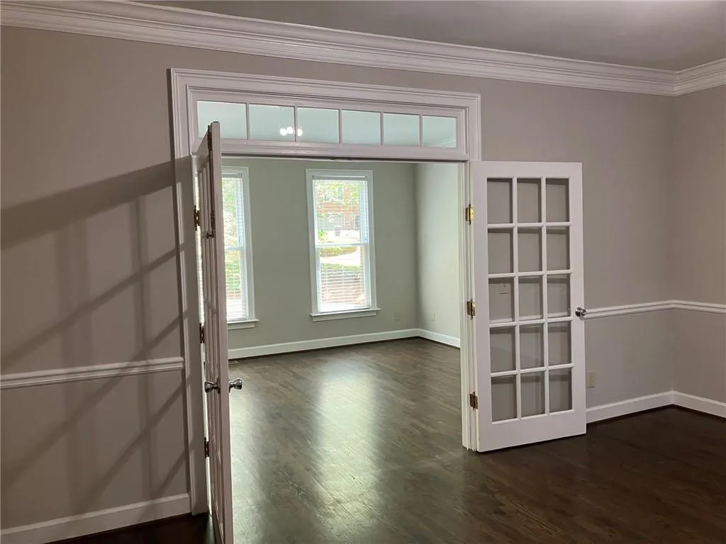 Foyer with ornamental molding, french doors, and dark hardwood / wood-style floors