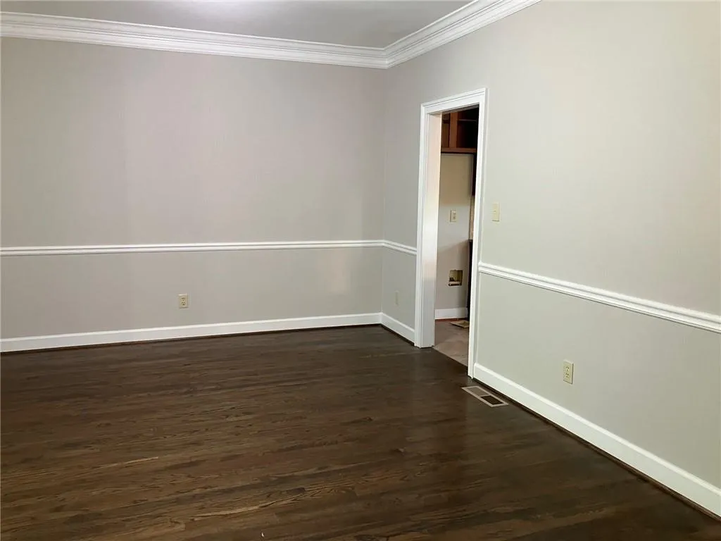 Spare room with crown molding and dark hardwood / wood-style floors
