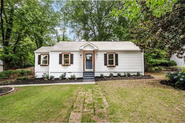 White siding exterior with black shutters and wood-frame windows
