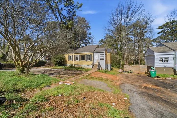 View of front of property featuring driveway, entry steps, and crawl space