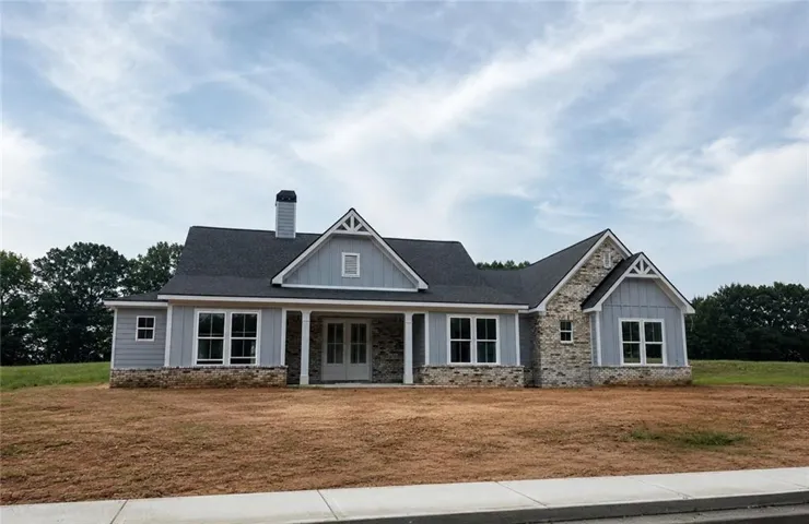 Craftsman-style exterior with a dark shingle roof, light gray siding, and stone accents