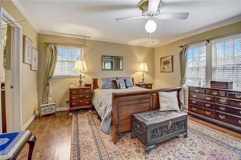 Bedroom with ornamental molding, ceiling fan, and wood-type flooring
