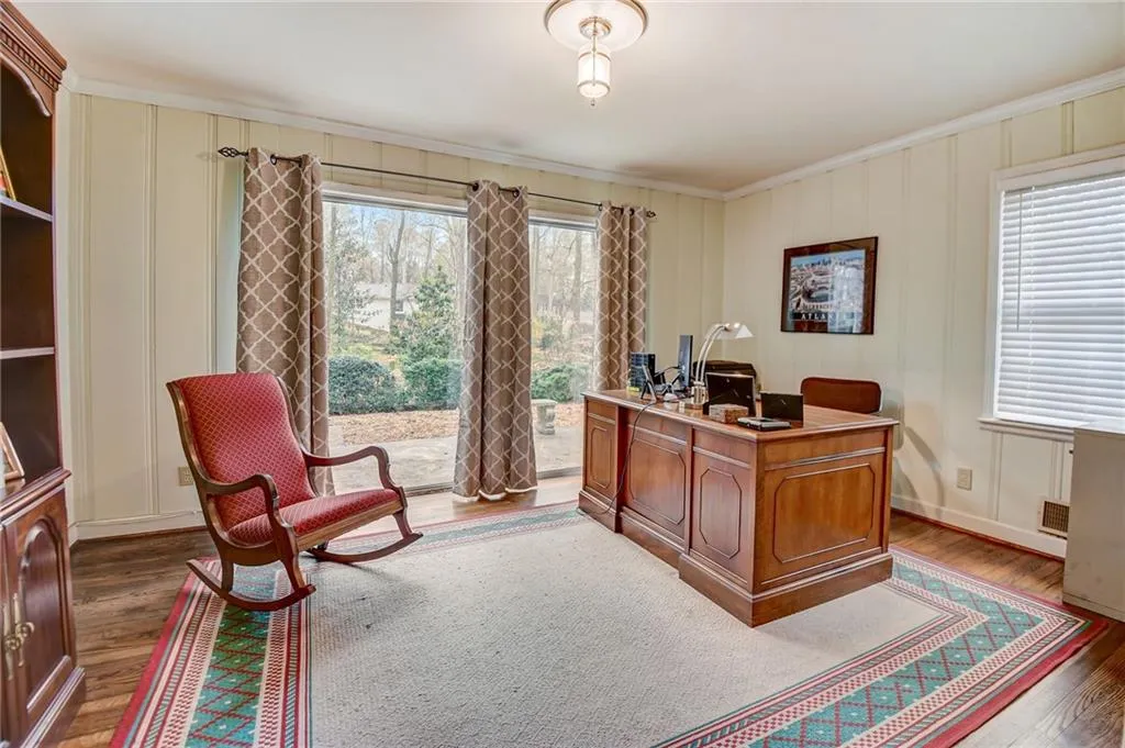 Office featuring dark hardwood / wood-style flooring, a healthy amount of sunlight, and crown molding