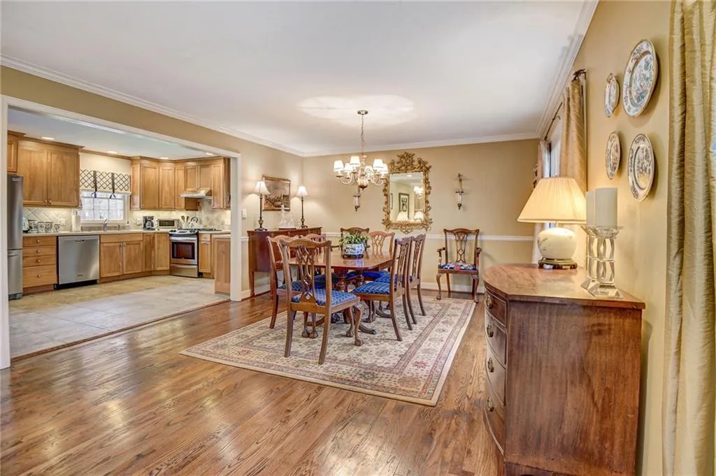 Tiled dining room with sink, crown molding, and a chandelier