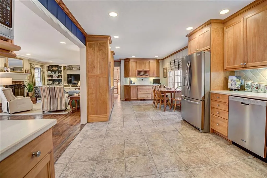 Kitchen featuring backsplash, stainless steel appliances, and light tile floors