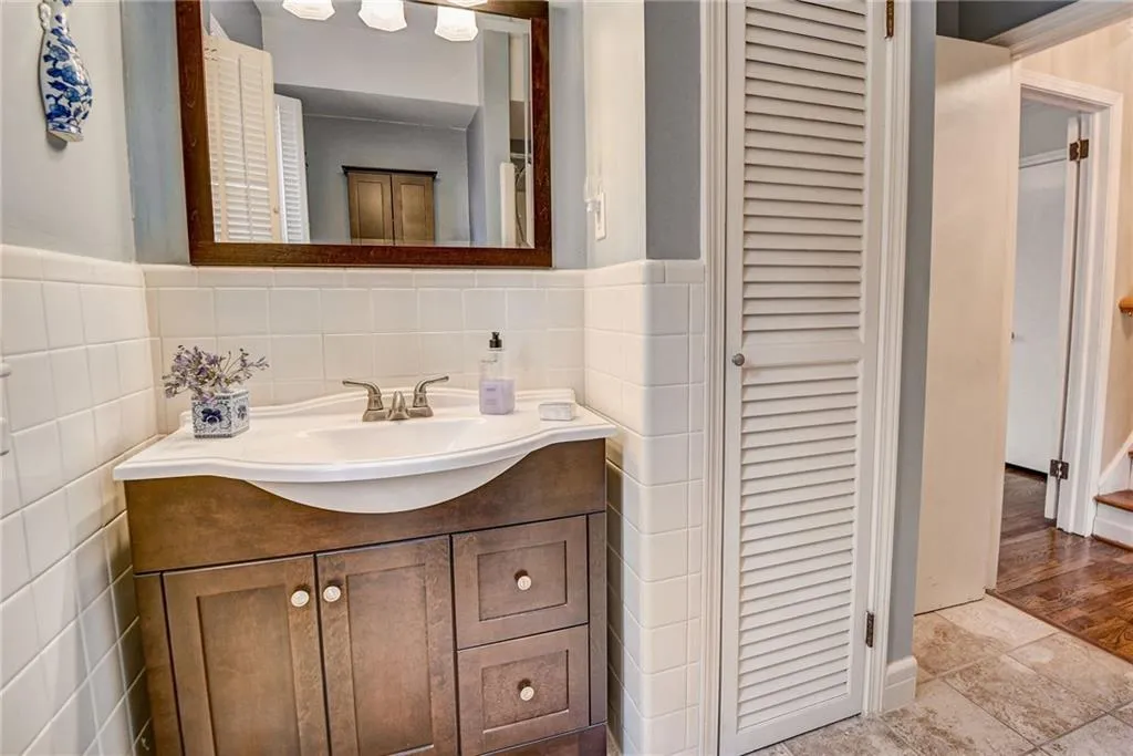 Bathroom with vanity, tile walls, tile flooring, and backsplash