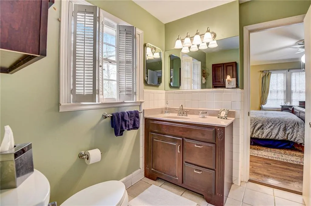 Bathroom with ceiling fan, backsplash, toilet, tile flooring, and vanity