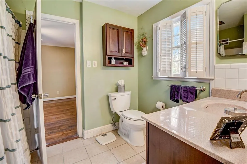 Bathroom featuring vanity, toilet, ornamental molding, and tile floors