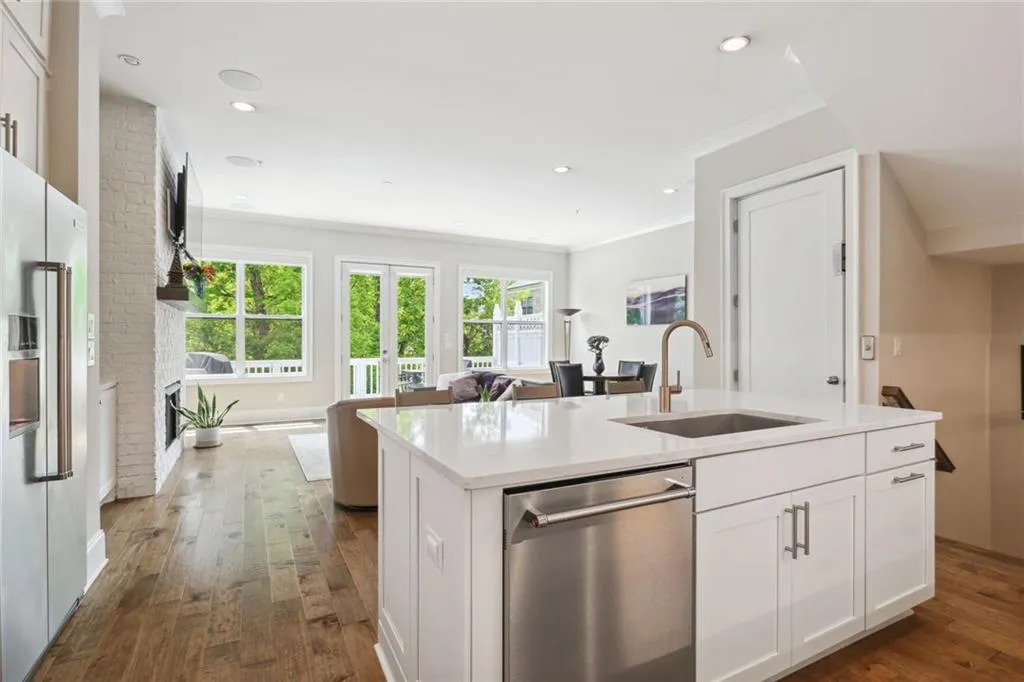 Kitchen opens into expansive living/dining room with views to pond and lush landscaping