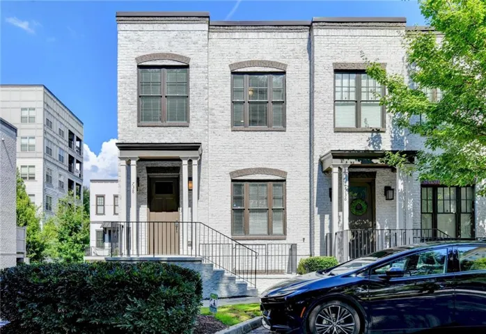 Contemporary white brick townhouse with dark trim accents