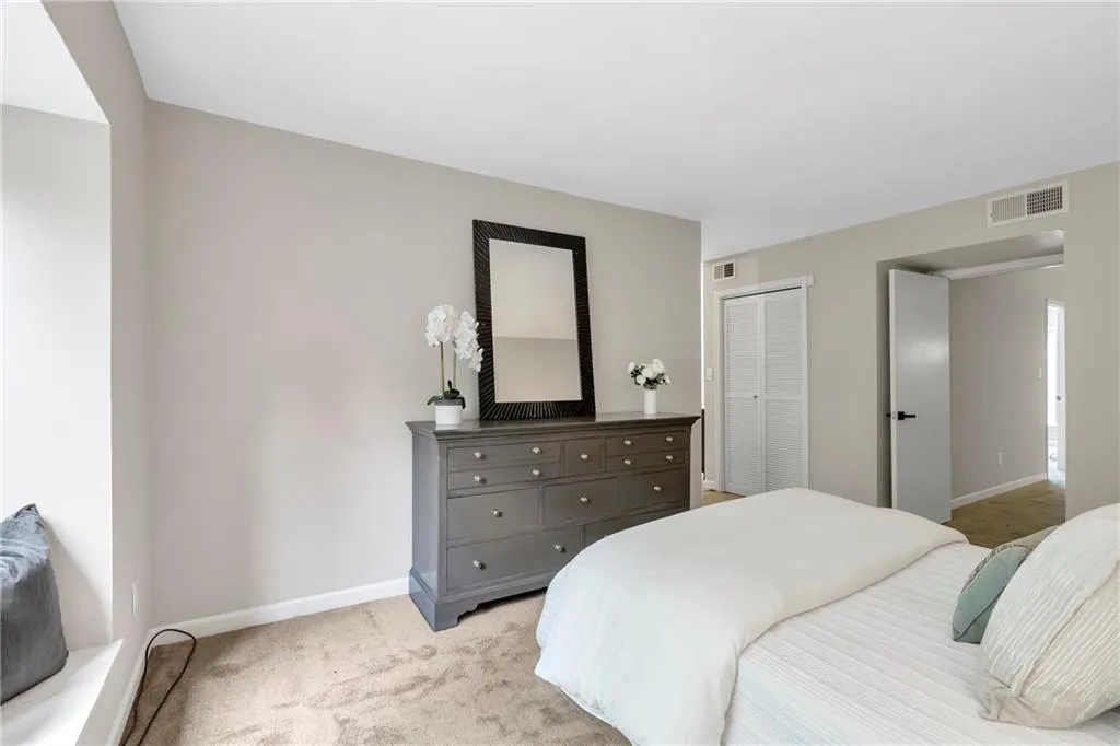 Bedroom featuring light carpet and a closet